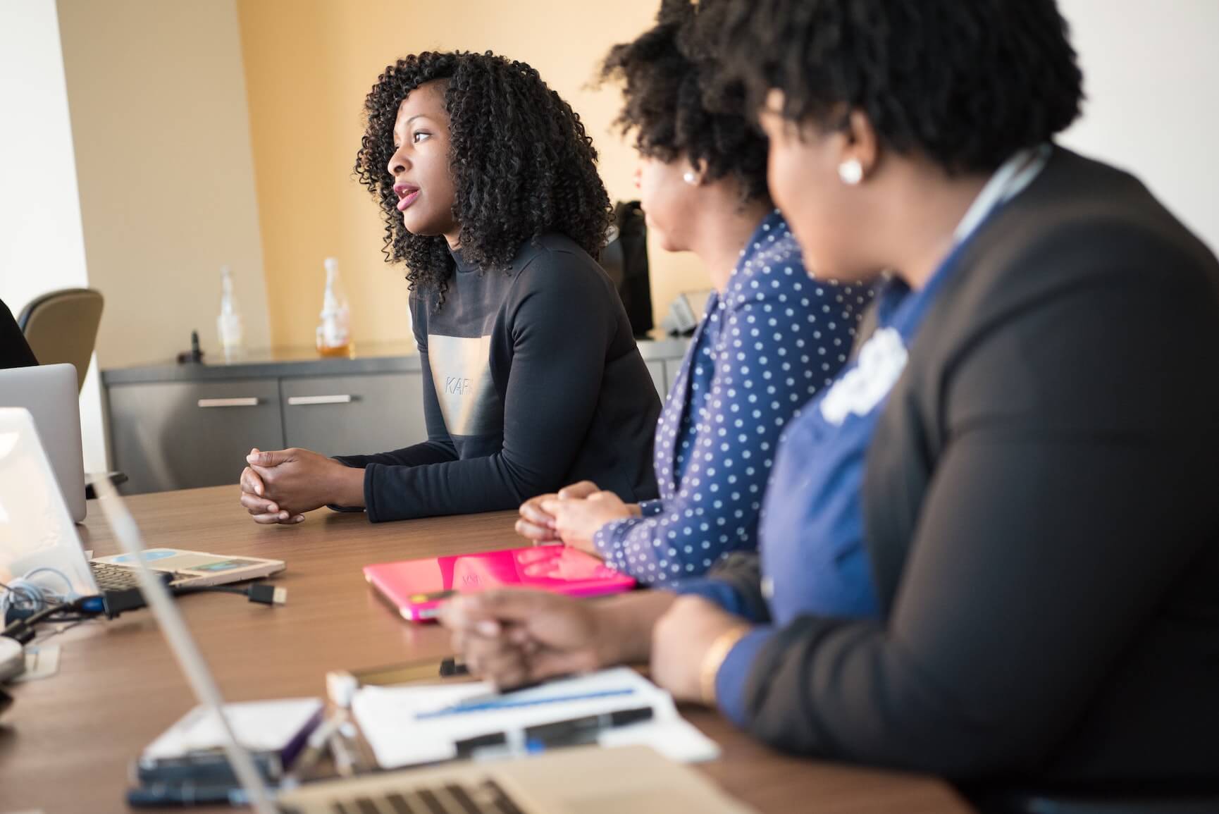 A group of colleagues discuss talent acquisition strategy in a meeting.