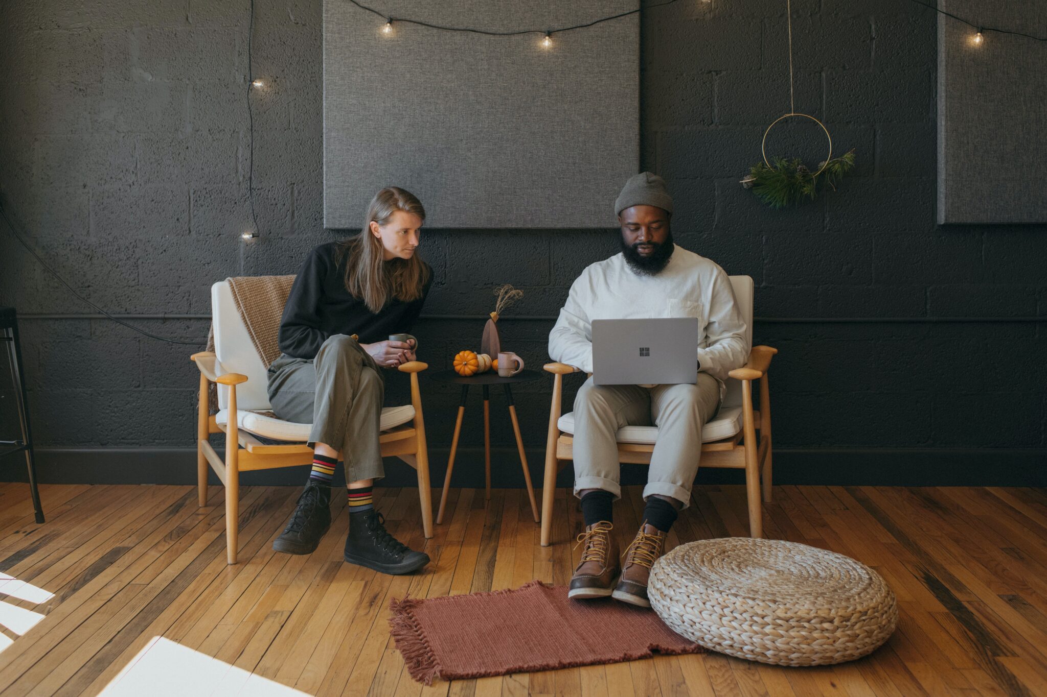 Two young men sitting in chairs looking at a laptop