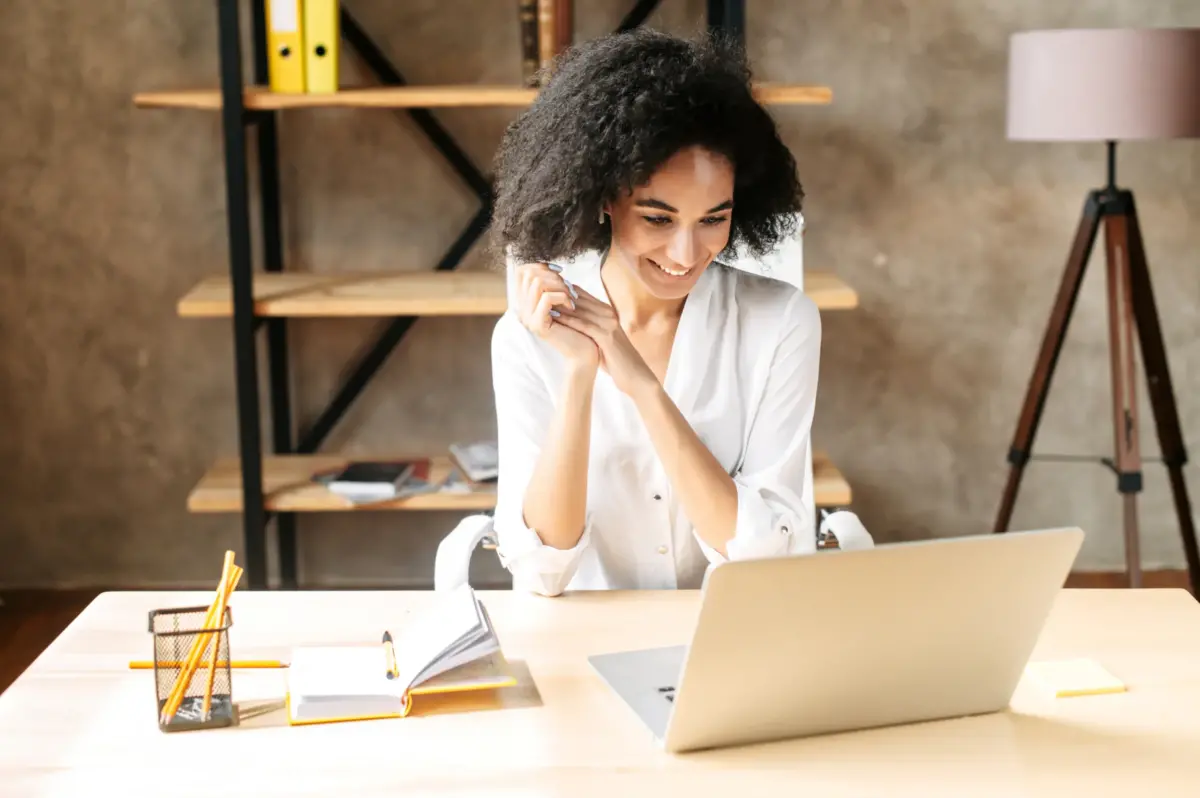 Talent Acquisition Manager smiling at findings on computer