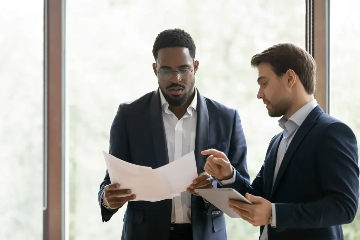 Two businessmen reviewing legal paperwork